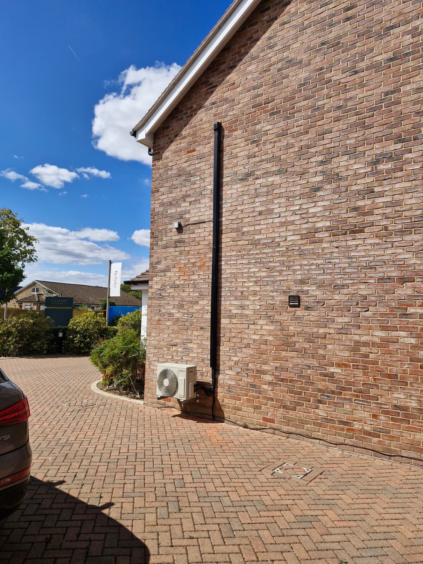 External Hitachi air conditioning condenser fitted to a brick wall