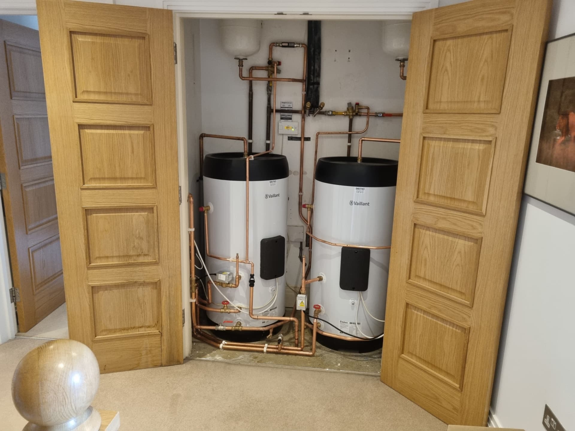 Two Vaillant unvented cylinders installed side by side in a cupboard