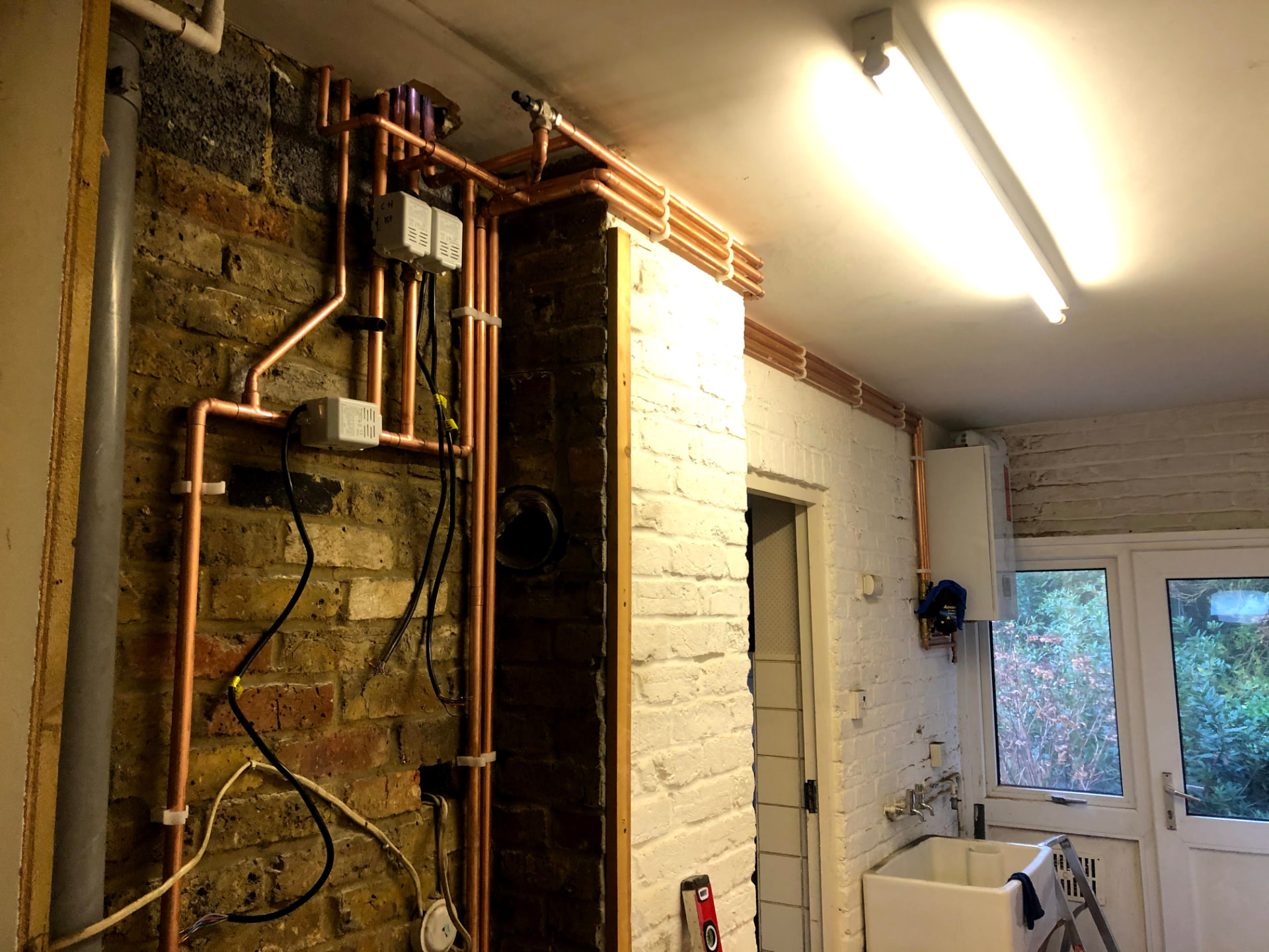 Copper heating pipework and zone valves installed in a utility room